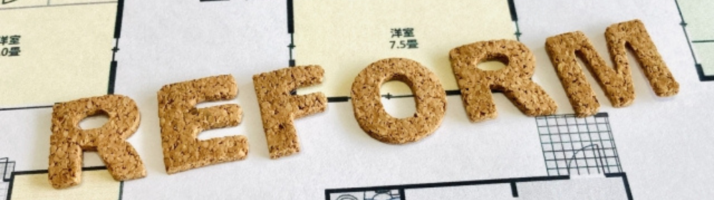 「間取り図の上に並べられたコルク素材の英字で構成された『REFORM』の文字」