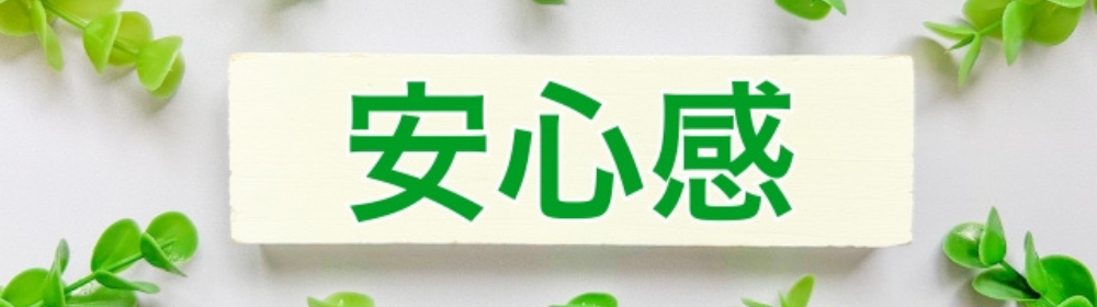緑の葉に囲まれた白いボードに『安心感』と書かれたシンプルで清潔感のある構成
