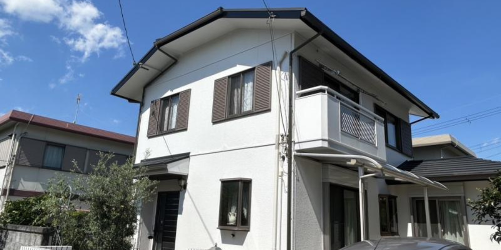 ガイソーで外壁塗装を終えた真っ白な二階建て住宅-青空の下で美しく仕上がった外観