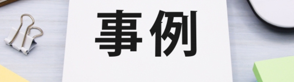 「白い用紙に黒文字で『事例』と書かれており、周囲にクリップやカラフルな付箋が並んでいる」