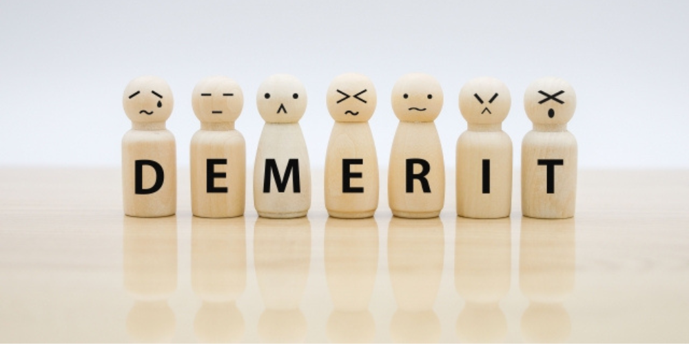 表情の異なる木製人形に「DEMERIT」の文字が一文字ずつ表示されている画像