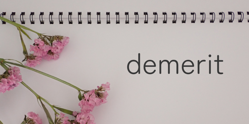 ノートと花とともに「demerit」と書かれたイメージ