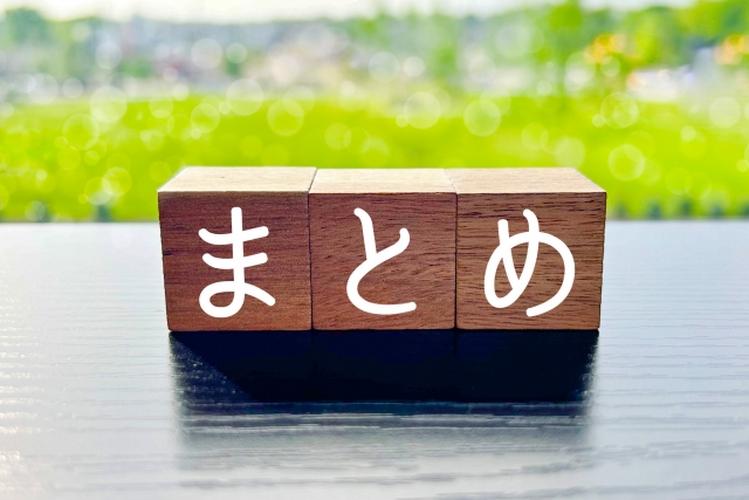 「『まとめ』と書かれた木製ブロックが並び、背景に緑の景色が広がる明るいイメージ」