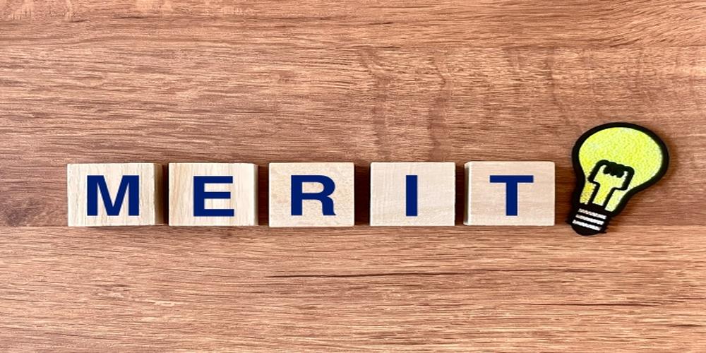 木目の背景に並んだ「MERIT」の文字ブロックと、電球のアイコンが並ぶメリットのイメージ。
