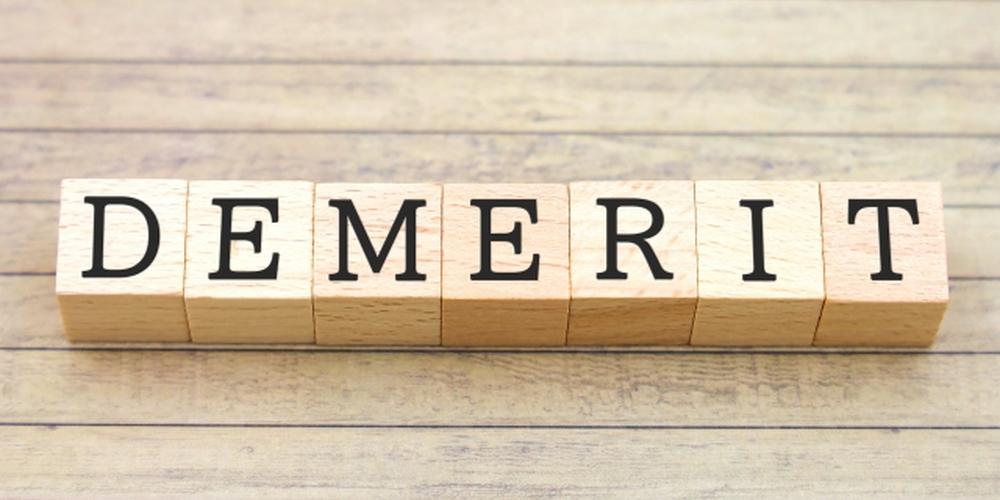 木目調の背景に「DEMERIT」と書かれた木製ブロックが一直線に並べられているイメージ