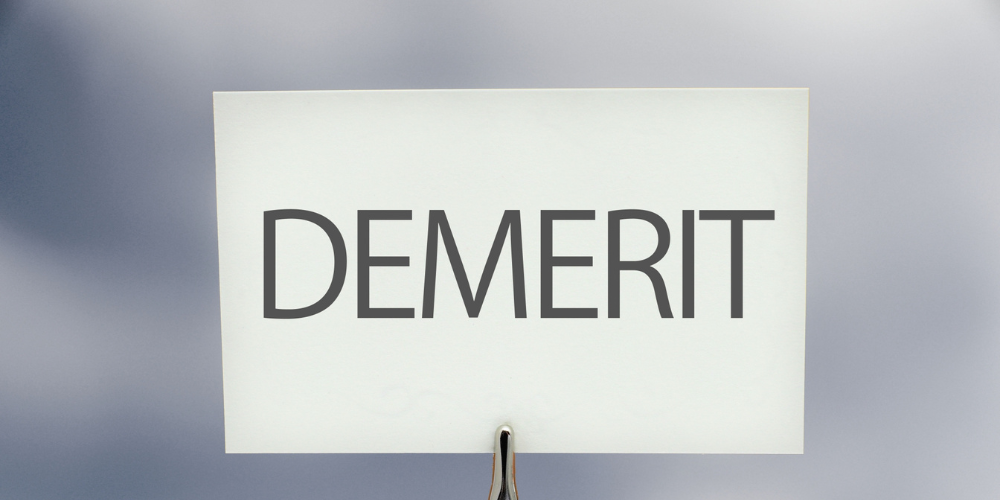 白いボードに書かれた「DEMERIT」の文字と赤いバツ印
