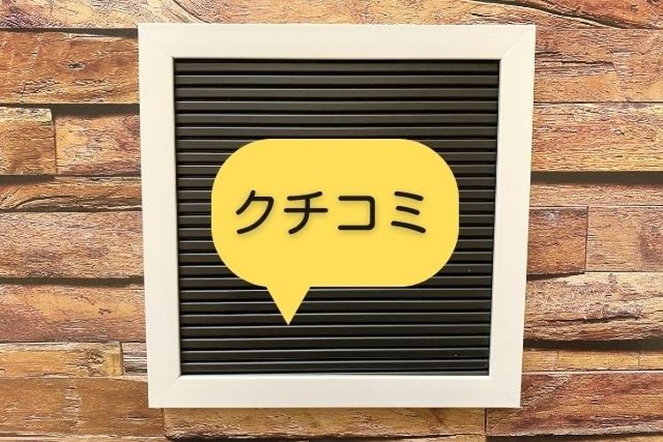 「黒いボードに『クチコミ』と書かれた黄色い吹き出しが貼られている、木目調の背景が印象的な掲示」