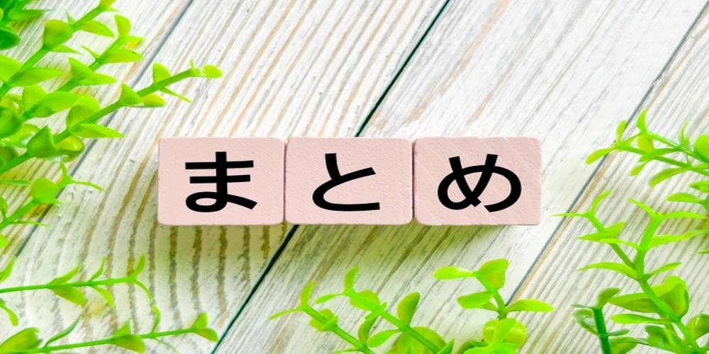 木目の背景にピンク色のブロックで「まとめ」と並べられ、周囲にグリーンの植物が添えられたイメージ。