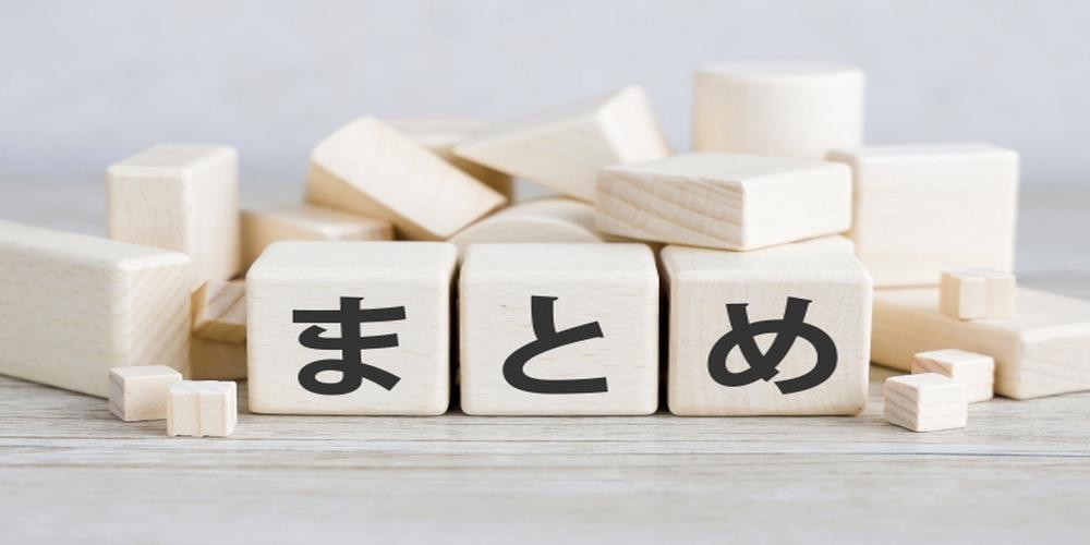 木製ブロックに「まとめ」と書かれた文字が並び、背景にはさまざまな形の積み木が置かれているイメージ。