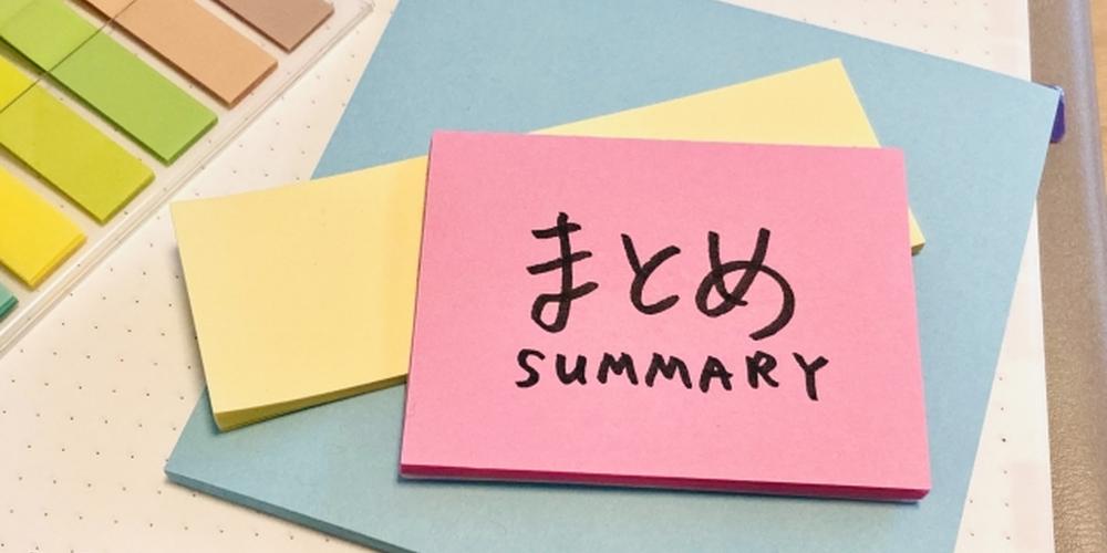 ピンク色の付箋に「まとめ SUMMARY」と書かれ、周囲に色とりどりの付箋やペンが並ぶデスク上のイメージ