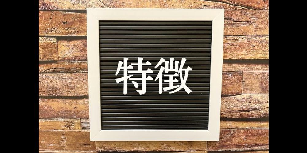 「黒板風フレームに白文字で『特徴』と書かれたボードが木目調の背景に映える画像」