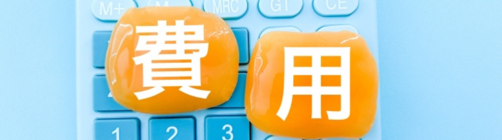 費用に関するイメージ。電卓の上に費用の文字が描かれたオレンジ色のジェル風オブジェが置かれている。