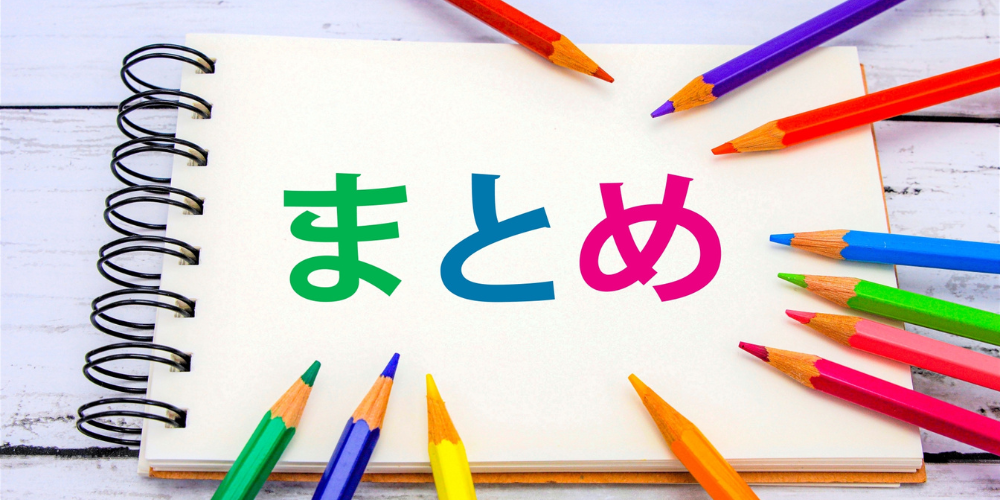 ノート中央にカラフルな「まとめ」の文字と色鉛筆が並ぶイメージ