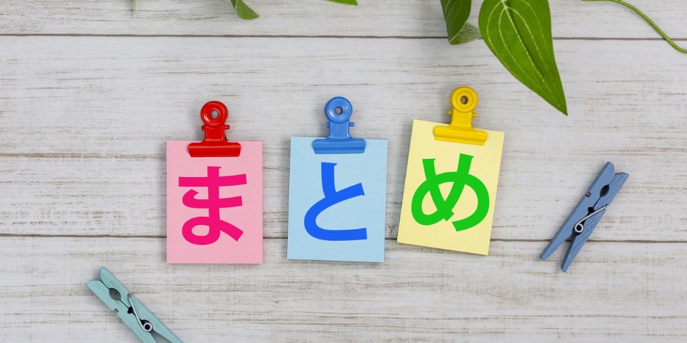 木目調の背景に、ひらがなで「まとめ」と書かれたクリップ付きのカラフルなメモ