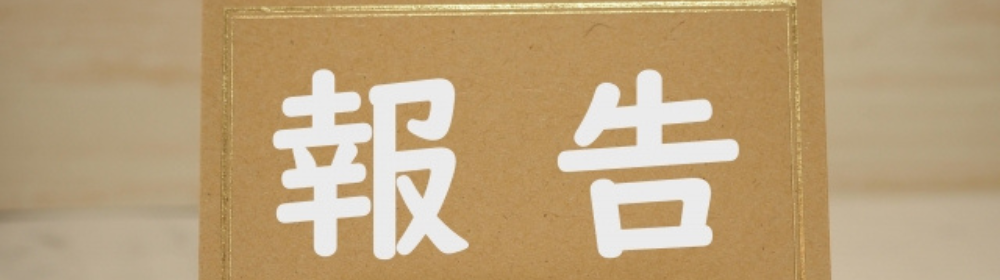 クラフト紙のカードに書かれた「報告」の白い文字。