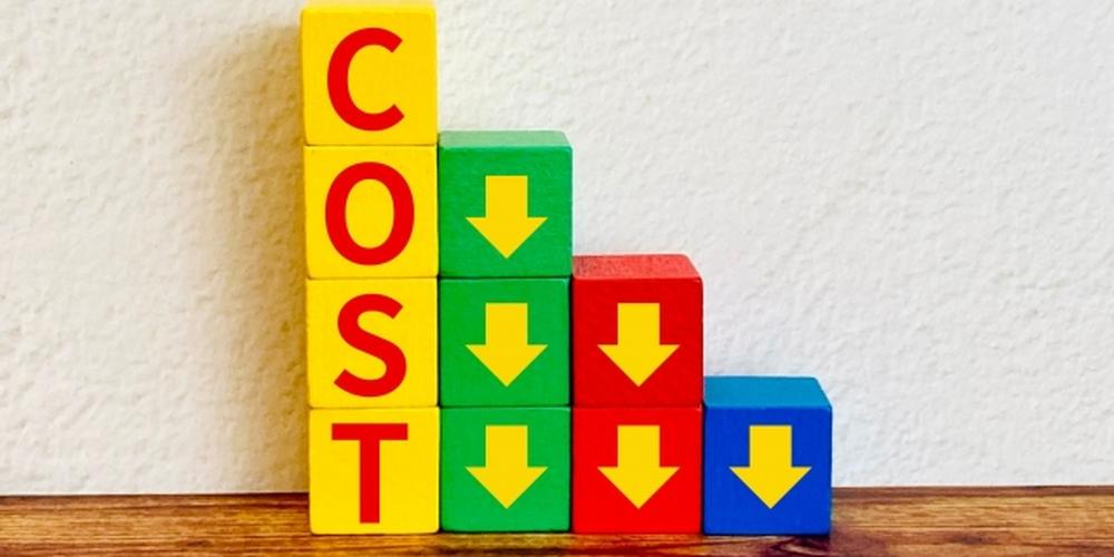カラフルなブロックで構成された「COST」の文字と、コスト削減を示す下向き矢印のイラスト 