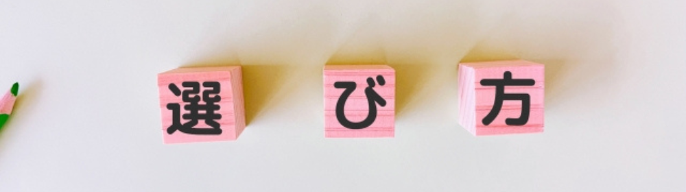 ピンクの積み木に「選び方」と書かれた文字が並び、左に緑の鉛筆が添えられた選定のイメージ