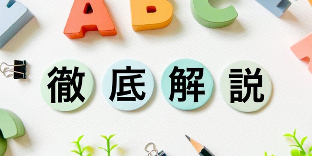 カラフルなアルファベットのオブジェや文具に囲まれた「徹底解説」の文字ブロック