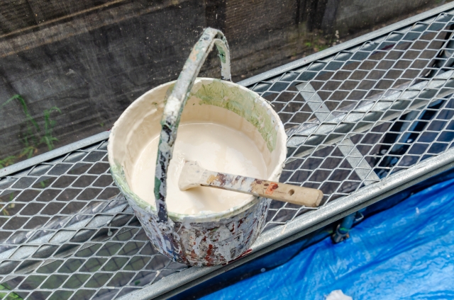 足場の上の置かれたペンキ缶