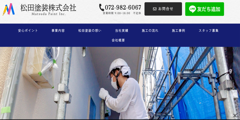 松田塗装株式会社の作業風景。養生された外壁と足場の中で、塗装作業に取り組む職人の様子