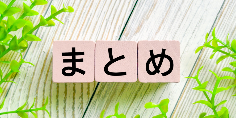 緑の植物の横に、ひらがなで「まとめ」と書かれたピンク色の積み木が置かれている