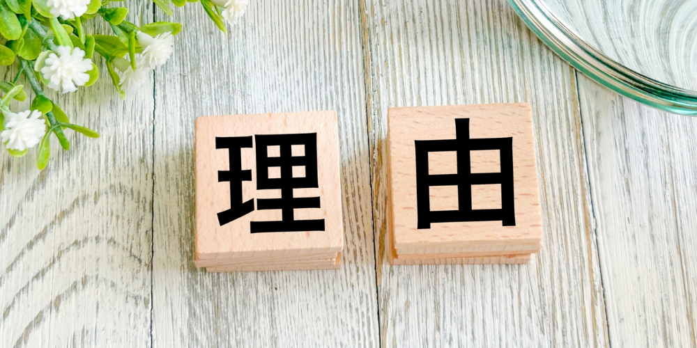 白木のデスクの上に「理」「由」と書かれた木製ブロックが並び、文章構成の理由紹介を示すイメージ