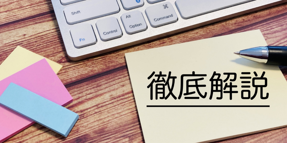 木製机上のキーボード端と付箋の隣に置かれたメモ紙に「徹底解説」と黒字で書かれた効率的な解説イメージ