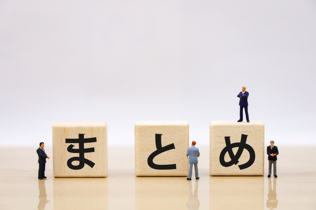 まとめと書かれた木のブロックと４人のビジネスマン