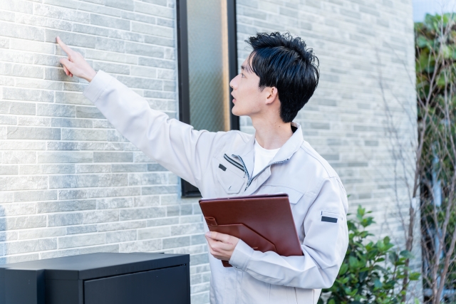 外壁をチェックする作業員